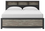 Ashley Furniture Broachmyn Bed with upholstered headboard and dark wood finish, viewed from the front showing detailed design.