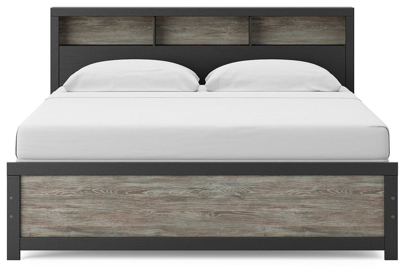 Ashley Furniture Broachmyn Bed with upholstered headboard and dark wood finish, viewed from the front showing detailed design.