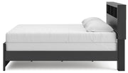 Ashley Furniture Broachmyn Bed in a cozy bedroom setting with a wooden headboard and matching frame.