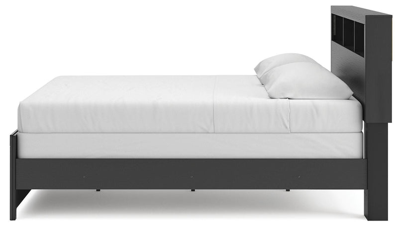 Ashley Furniture Broachmyn Bed in a cozy bedroom setting with a wooden headboard and matching frame.