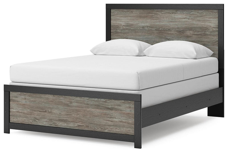 Ashley Furniture Broachmyn Bed with a stylish upholstered headboard and wooden frame, shown from an angled view.