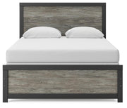 Ashley Furniture Broachmyn Bed with a headboard featuring detailed woodwork and a classic design in a cozy bedroom setting.