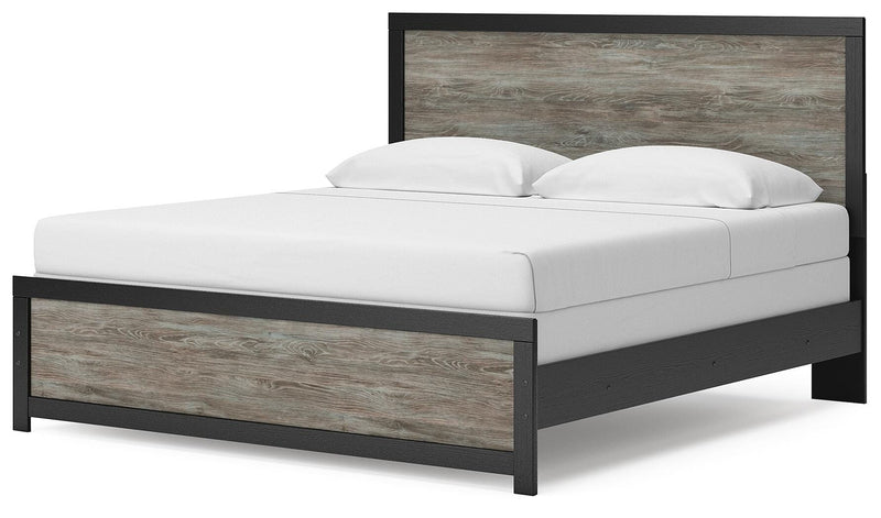 Ashley Furniture Broachmyn Bed with a stylish upholstered headboard and wood frame, shown from an angled view.
