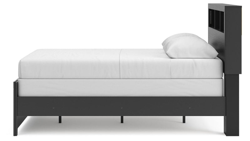 Ashley Furniture Broachmyn Bed with a wooden frame and headboard, shown from a side angle in a modern bedroom setting.