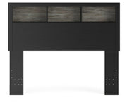Ashley Furniture Broachmyn Bed with a headboard featuring detailed wood carvings and a dark finish, shown in a stylish bedroom setting.