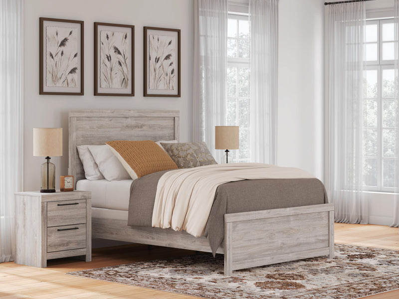 Ashley Furniture Broachmyn Bed with a wooden frame and upholstered headboard, shown in a modern bedroom setting.