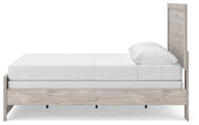 Ashley Furniture Broachmyn Bed with a stylish headboard and wooden frame, shown from a side angle in a modern bedroom setting.