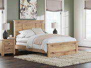 Ashley Furniture Makidern Bed with upholstered headboard and wooden frame, shown in a cozy bedroom setting.