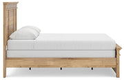 Ashley Furniture Makidern Bed with a wooden frame and side panels, shown from a side angle in a bedroom setting.