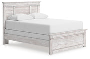 Ashley Furniture Makidern Bed with a stylish headboard and wooden frame, shown from a side angle.