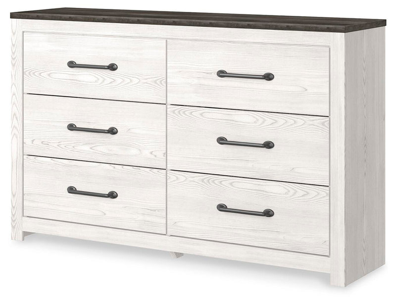Ashley Furniture Gerridan Dresser with multiple drawers, shown from an angled side view in a modern bedroom setting.