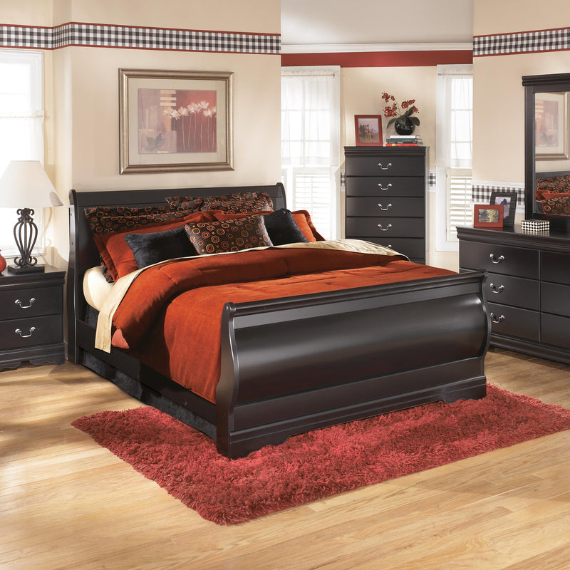 Ashley Furniture Huey Vineyard Bed with a classic wooden frame and neutral upholstery, shown in a cozy bedroom setting.