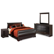 Ashley Furniture Huey Vineyard bedroom set with a bed, dresser, and nightstands in a classic design, shown in a cozy bedroom setting.