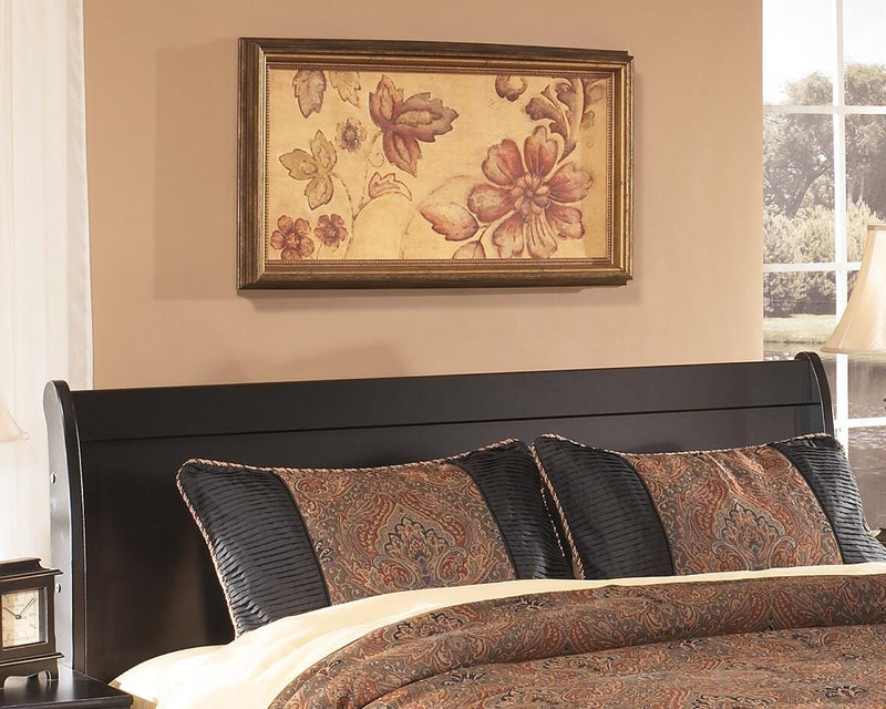 Ashley Furniture Huey Vineyard Bed in a cozy bedroom setting, showcasing the stylish wood frame and neutral upholstery.
