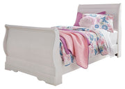Ashley Furniture Anarasia Bed with a wooden frame and decorative headboard in a cozy bedroom setting