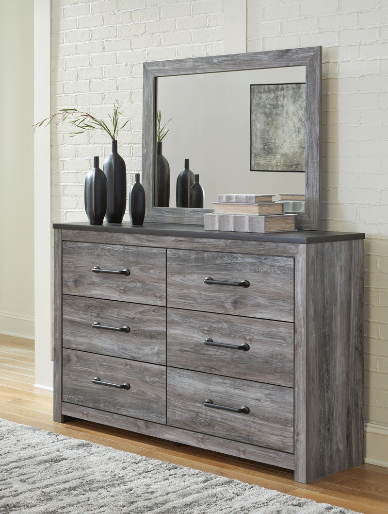Ashley Furniture Bronyan bedroom set with a bed, dresser, and nightstands in a modern design, shown in a cozy bedroom setting.