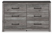 Ashley Furniture Bronyan dresser with sleek wood finish, featuring multiple drawers and modern hardware in a contemporary bedroom setting.