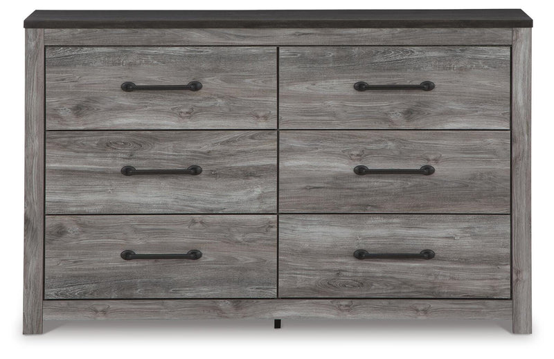 Ashley Furniture Bronyan dresser with sleek wood finish, featuring multiple drawers and modern hardware in a contemporary bedroom setting.