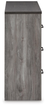 Ashley Furniture Bronyan dresser with sleek wood finish and multiple drawers, shown in a stylish bedroom setting.