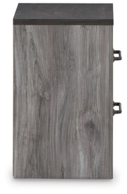 Ashley Furniture Bronyan nightstand with a dark wood finish, featuring a single drawer and a lower shelf for bedside storage.