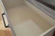 Ashley Furniture Bronyan chest of drawers with a sleek wood finish and modern design, featuring multiple storage drawers.