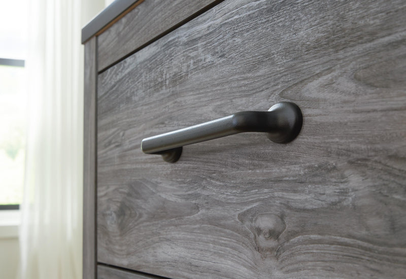 Ashley Furniture Bronyan dresser with matching mirror, showcasing sleek wood finish and modern handle details.