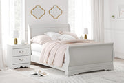 Ashley Furniture Anarasia Bed with a stylish wooden frame and upholstered headboard, shown in a cozy bedroom setting.