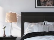 Close-up of Ashley Furniture Maribel Bed with detailed wooden headboard and rich dark finish.