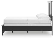 Ashley Furniture Maribel Bed in a cozy bedroom setting with a stylish upholstered headboard and elegant wooden frame.