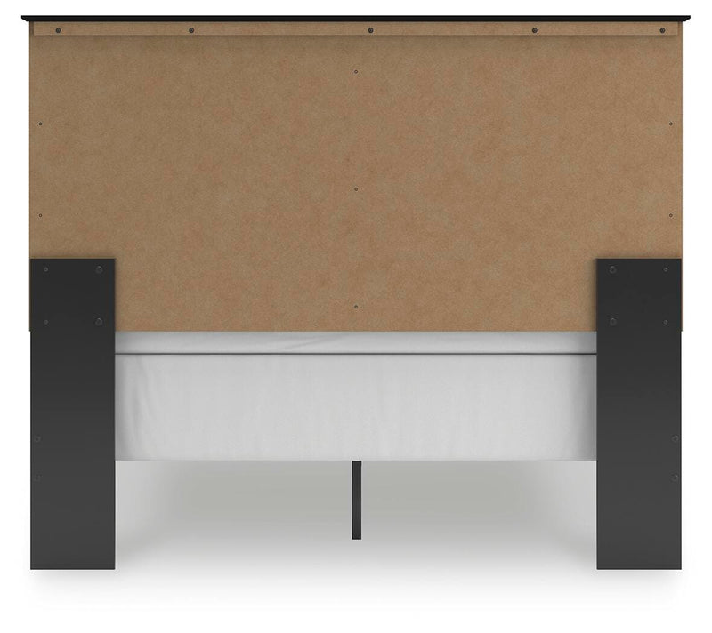 Ashley Furniture Maribel Bed with upholstered headboard and wooden frame, shown in a cozy bedroom setting.