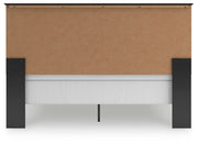 Ashley Furniture Maribel Bed with upholstered headboard and wooden frame, shown from the back in a bedroom setting.