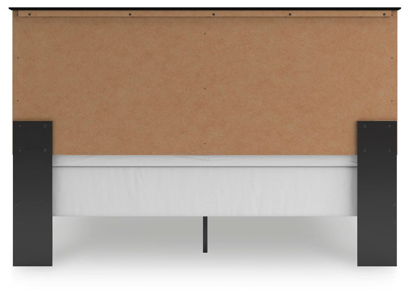 Ashley Furniture Maribel Bed with upholstered headboard and wooden frame, shown from the back in a bedroom setting.