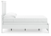Ashley Furniture Bostwick Shoals Bed in warm wood finish with a classic headboard and sturdy frame, shown from the side.