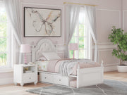 Ashley Furniture Kozlani upholstered bed with a padded headboard and neutral fabric finish, showcasing a stylish bedroom centerpiece.
