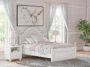 Ashley Furniture Kozlani upholstered bed with a padded headboard and neutral fabric, shown in a modern bedroom setting.