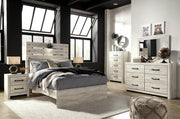 Ashley Furniture Cambeck Bed with dark wood finish and panel headboard, shown in a modern bedroom setting.