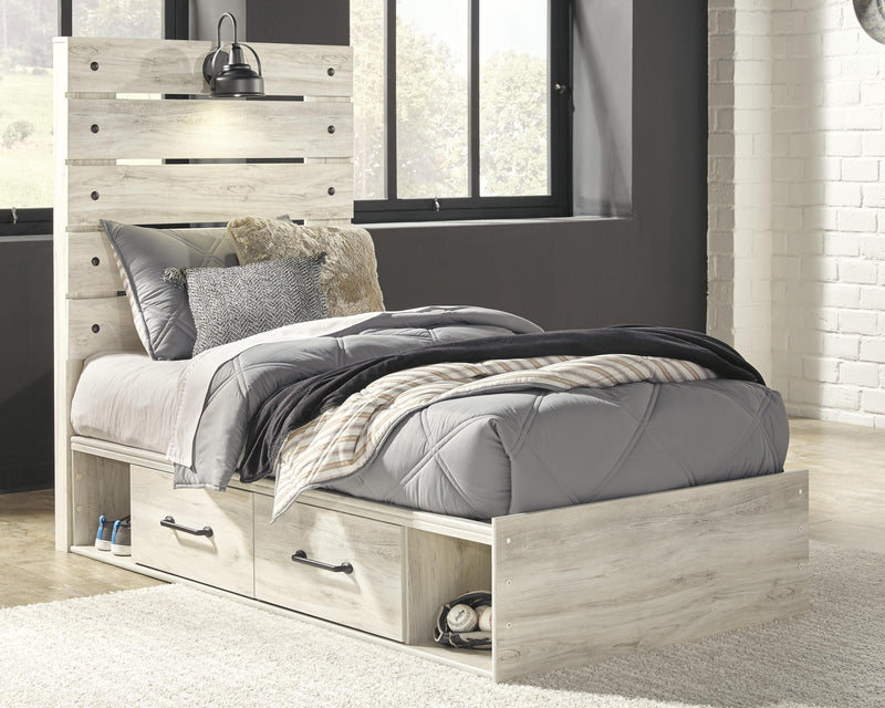 Ashley Furniture Cambeck bed with four storage drawers in a modern bedroom setting featuring a wooden frame and sleek design.