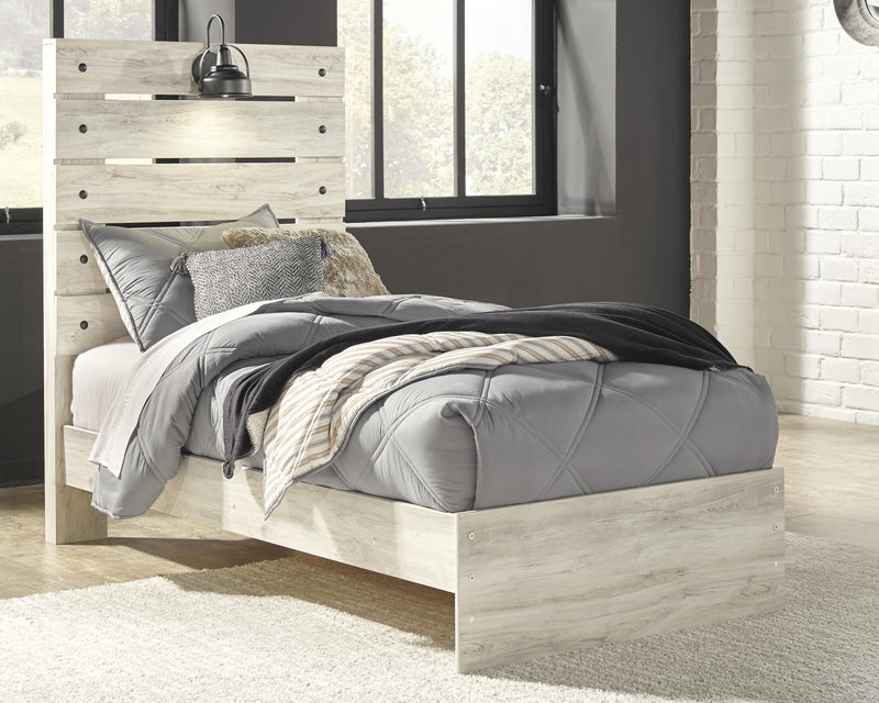 Ashley Furniture Cambeck Bed with a wooden frame and detailed headboard, shown in a cozy bedroom setting.
