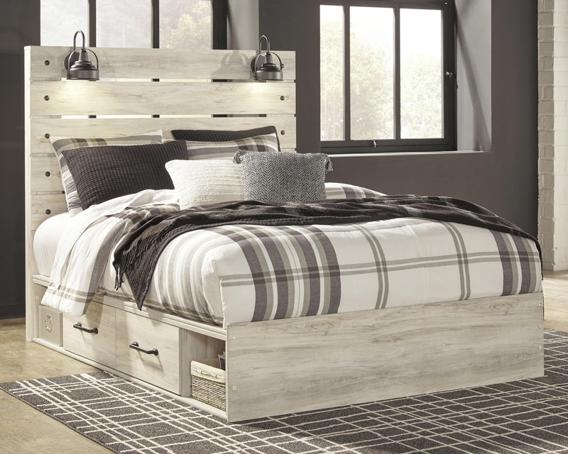 Ashley Furniture Cambeck bed with two storage drawers, showcasing a stylish wooden bed frame with built-in storage in a modern bedroom setting.