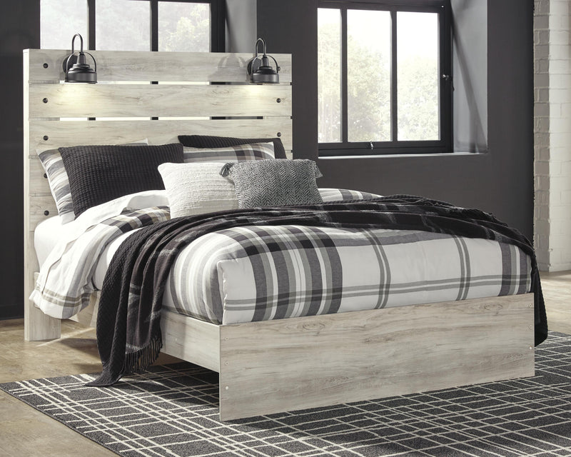 Ashley Furniture Cambeck Bed with a wooden frame and detailed headboard, shown in a cozy bedroom setting.