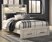 Ashley Furniture Cambeck Bed with two storage drawers, wooden frame, and clean design, shown in a bedroom setting.