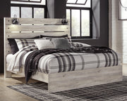Ashley Furniture Cambeck bed with a wooden frame and upholstered headboard, shown in a cozy, stylish bedroom setting.