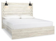 Ashley Furniture Cambeck Bed with a stylish wood frame and angled headboard, shown from a side angle in a well-lit bedroom scene.