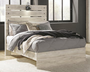 Ashley Furniture Cambeck Bed with a wooden frame and upholstered headboard, shown in a modern bedroom setting.