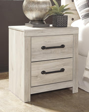 Ashley Furniture Cambeck nightstand with a sleek wood finish and modern design, featuring a single drawer and open storage space.