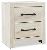 Ashley Furniture Cambeck nightstand with a closed drawer and wooden finish, shown from an angled side view.