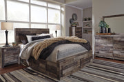 Ashley Furniture Derekson bed with four storage drawers, dark wood finish, and upholstered headboard in a bedroom setting.