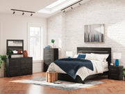 Ashley Furniture Hollivern Bed with a modern design, featuring a wooden frame and stylish headboard in a cozy bedroom setting.