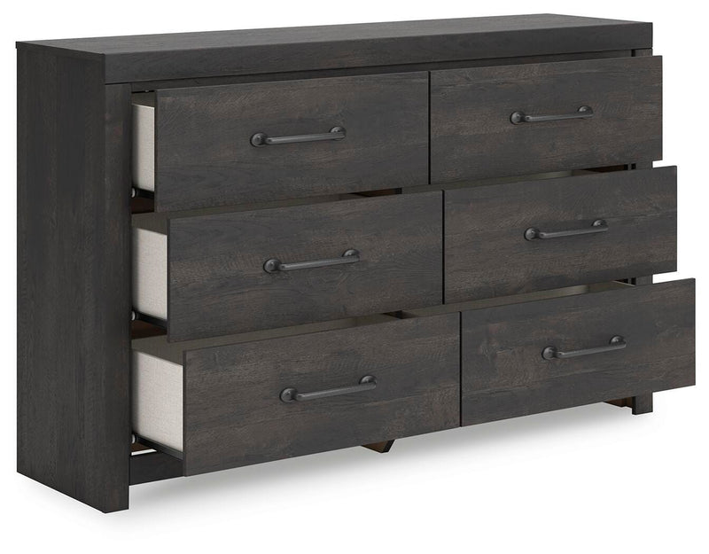 Open view of Ashley Furniture Hollivern dresser showing multiple spacious drawers and wood finish in a modern bedroom setting.