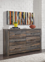 Ashley Furniture Drystan dresser with multiple drawers and a dark wood finish, shown in a modern bedroom setting.